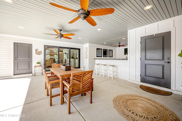 view of patio with outdoor dining area and a ceiling fan