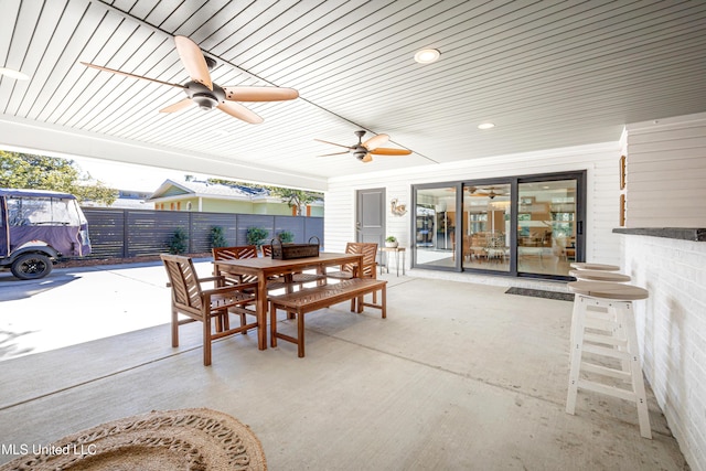 view of patio / terrace featuring outdoor dining area, fence, and a ceiling fan