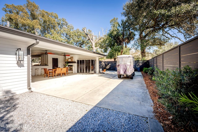 view of patio / terrace featuring a fenced backyard, ceiling fan, and driveway