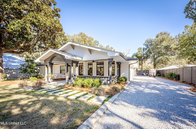 view of front of home with driveway, fence, and a porch