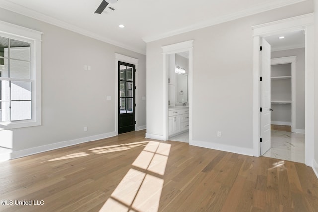 unfurnished bedroom with light hardwood / wood-style floors, a walk in closet, ensuite bathroom, and a closet