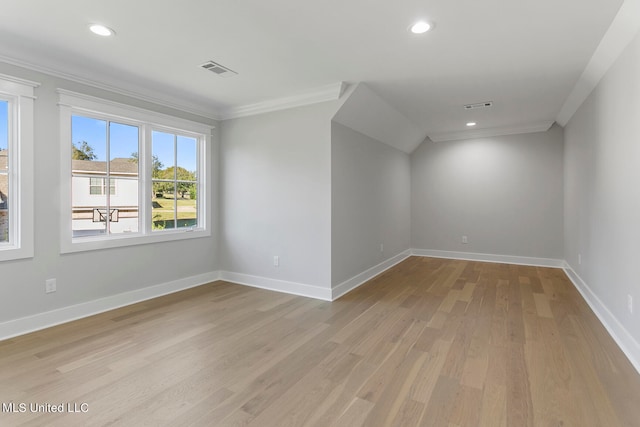 spare room with ornamental molding and light wood-type flooring