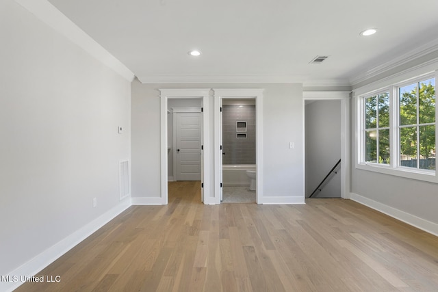 unfurnished bedroom featuring ornamental molding, ensuite bathroom, and light wood-type flooring