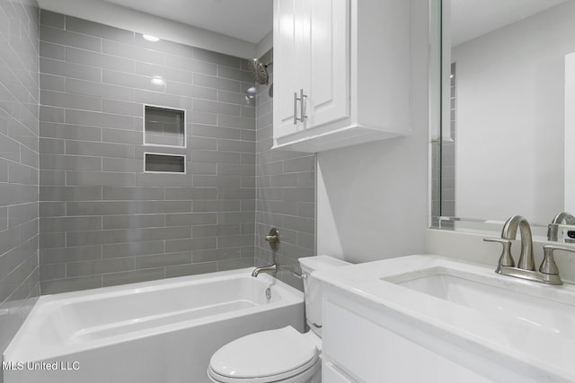 full bathroom featuring toilet, tiled shower / bath, and vanity