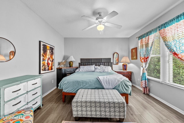 bedroom with wood-type flooring, a textured ceiling, and ceiling fan