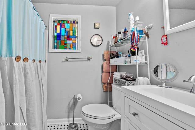 bathroom with tile patterned flooring, vanity, a textured ceiling, and toilet