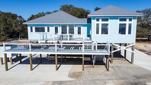 6717 Belle Fontaine Dr, Ocean Springs, MS 39564 - rear view of house featuring a wooden deck, a carport, driveway, and metal roof