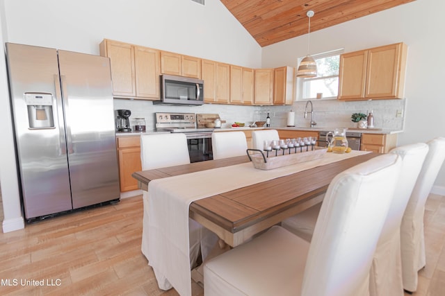 6717 Belle Fontaine Dr, Ocean Springs, MS 39564 - kitchen with light wood-style flooring, appliances with stainless steel finishes, light brown cabinetry, and tasteful backsplash