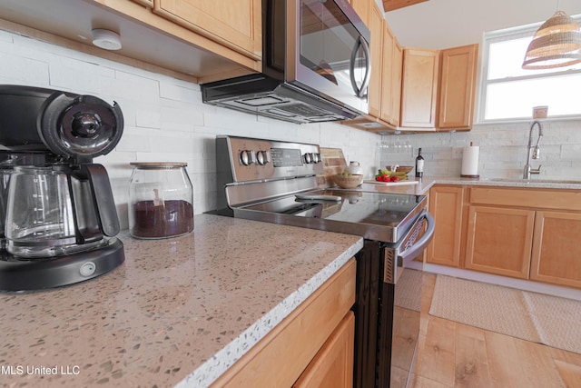 6717 Belle Fontaine Dr, Ocean Springs, MS 39564 - kitchen with decorative backsplash, light brown cabinetry, light stone countertops, a sink, and stainless steel appliances