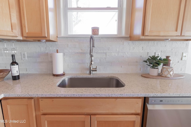 6717 Belle Fontaine Dr, Ocean Springs, MS 39564 - kitchen featuring light brown cabinetry, tasteful backsplash, dishwasher, a sink, and light stone counters