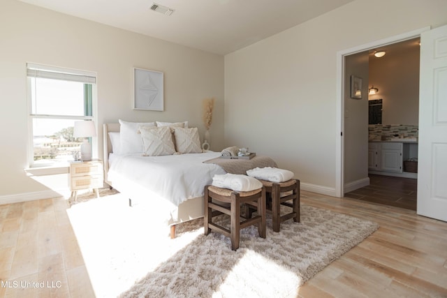 6717 Belle Fontaine Dr, Ocean Springs, MS 39564 - bedroom featuring baseboards, visible vents, light wood-style flooring, and ensuite bathroom