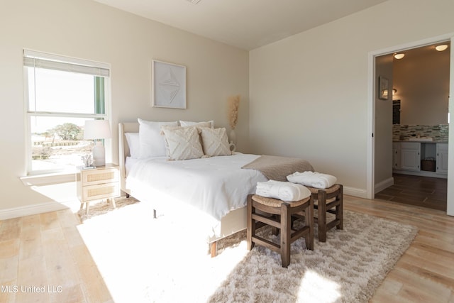 6717 Belle Fontaine Dr, Ocean Springs, MS 39564 - bedroom featuring baseboards, ensuite bath, and wood finished floors