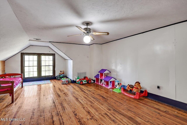 rec room with vaulted ceiling, ceiling fan, hardwood / wood-style floors, and a textured ceiling