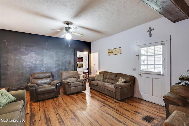 living room with ceiling fan, wood-type flooring, and a textured ceiling