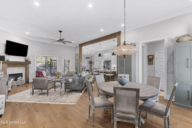 dining space featuring ceiling fan with notable chandelier and light hardwood / wood-style floors