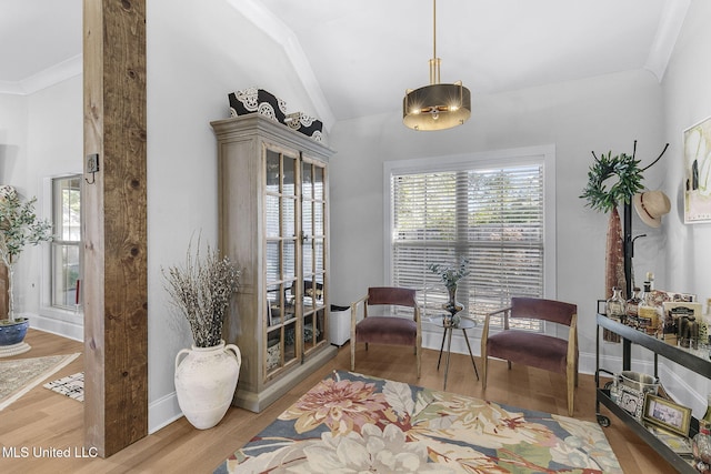 sitting room featuring crown molding, light hardwood / wood-style floors, and lofted ceiling