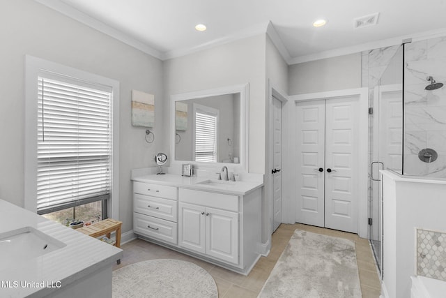 bathroom featuring ornamental molding, vanity, and a healthy amount of sunlight