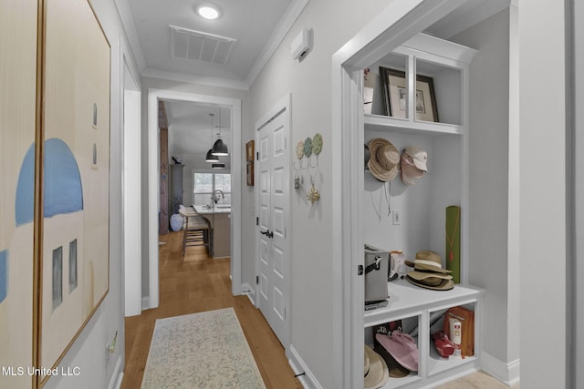 mudroom with crown molding and light hardwood / wood-style flooring