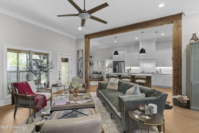 living room with ceiling fan, light wood-type flooring, and crown molding