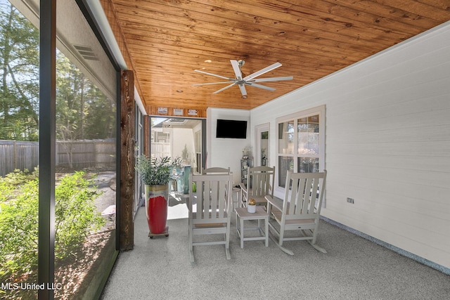 unfurnished sunroom featuring plenty of natural light, wooden ceiling, and ceiling fan