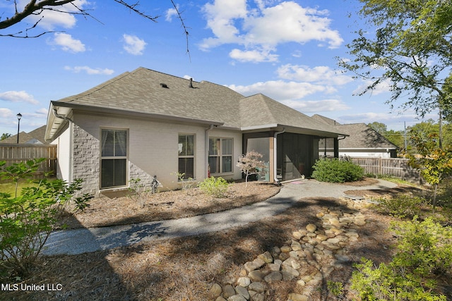 rear view of property featuring a sunroom