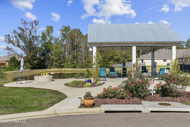 surrounding community featuring a gazebo, a patio area, a yard, and a water view