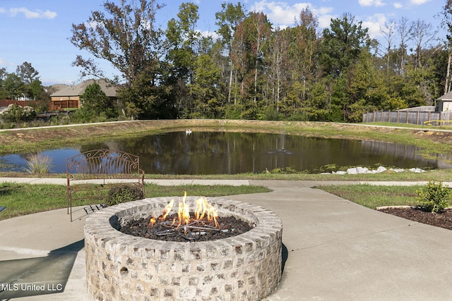 exterior space with a water view and a fire pit