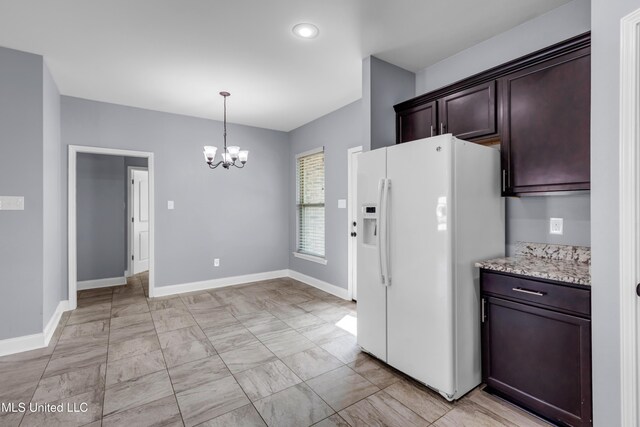 832 Reunion Place Cir, Biloxi, MS 39532 - kitchen with white refrigerator with ice dispenser, a chandelier, light marble finish floors, baseboards, and dark brown cabinets