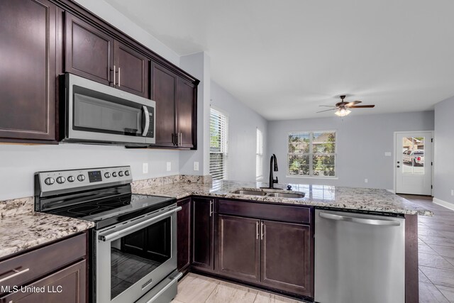 832 Reunion Place Cir, Biloxi, MS 39532 - kitchen with appliances with stainless steel finishes, a sink, a peninsula, ceiling fan, and light stone countertops