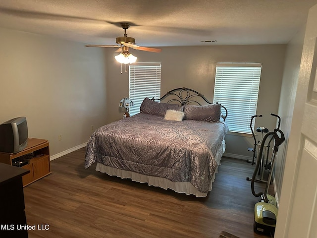 bedroom featuring a textured ceiling, ceiling fan, and dark hardwood / wood-style flooring