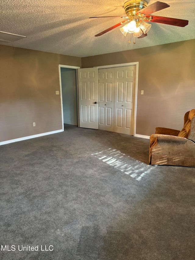 interior space with dark colored carpet, a textured ceiling, and ceiling fan