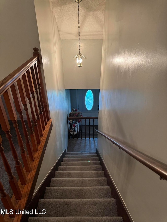 stairway with a textured ceiling