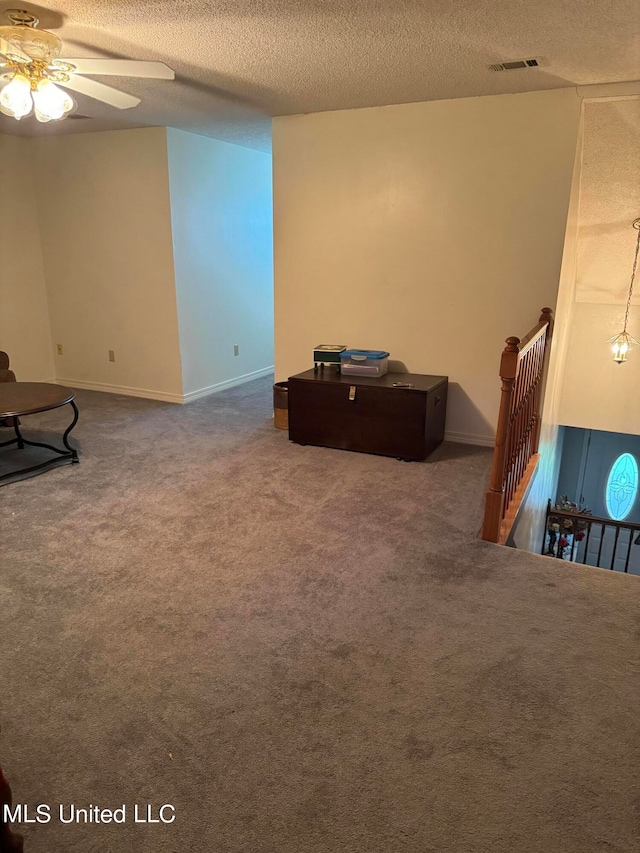 interior space with ceiling fan and a textured ceiling