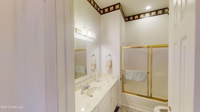 full bathroom featuring vanity, combined bath / shower with glass door, and toilet