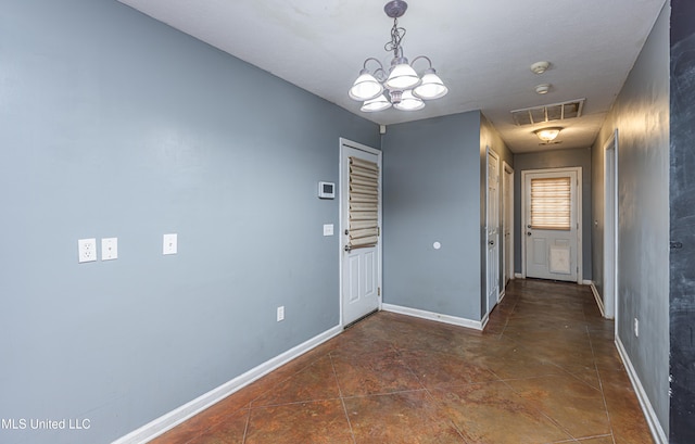 interior space featuring dark tile patterned floors and a chandelier