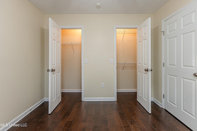 unfurnished bedroom featuring dark hardwood / wood-style flooring and a spacious closet