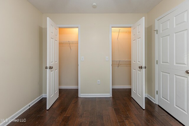 159 Basswood Cir, Brandon, MS 39047 - unfurnished bedroom with a walk in closet and dark wood finished floors