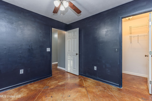 tiled empty room featuring ceiling fan