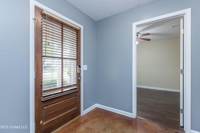 entryway featuring ceiling fan, dark hardwood / wood-style flooring, and a textured ceiling