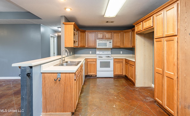 kitchen featuring kitchen peninsula, white appliances, and sink