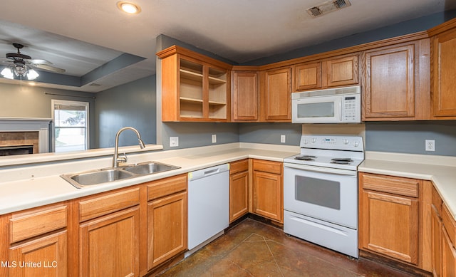 kitchen featuring white appliances, a tile fireplace, dark tile patterned flooring, sink, and ceiling fan