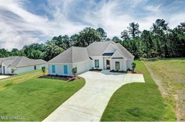 view of front facade with concrete driveway, a front yard, and a garage