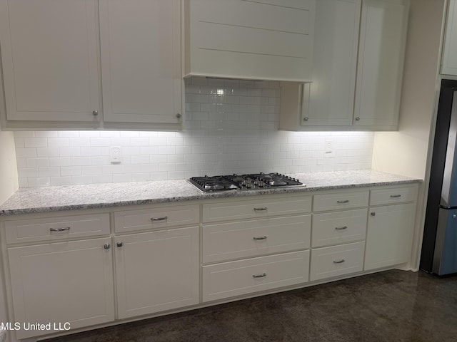kitchen featuring decorative backsplash, white cabinetry, light stone countertops, and stainless steel appliances
