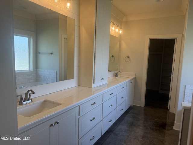 bathroom featuring double vanity, a washtub, a sink, and finished concrete floors