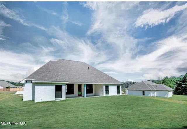 back of property with a lawn