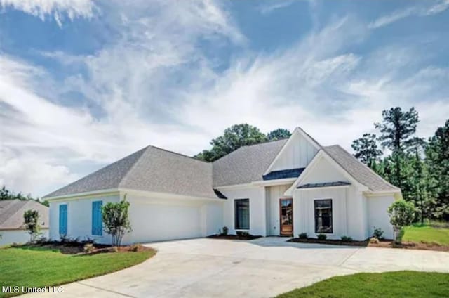 view of front facade featuring a garage, a front lawn, board and batten siding, and driveway