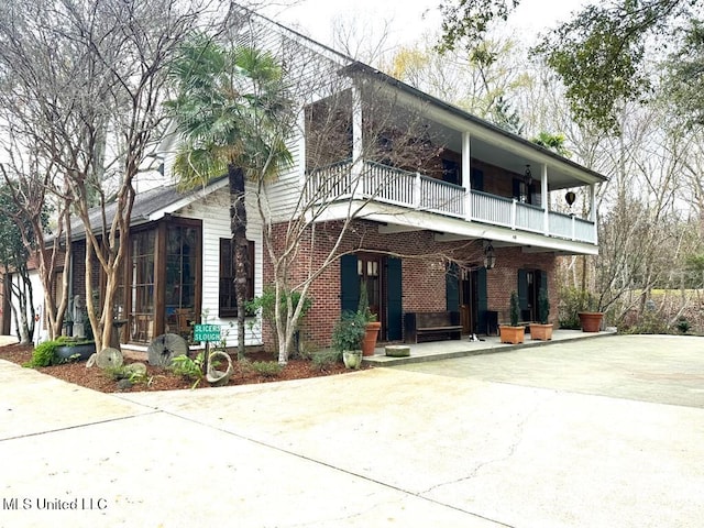 view of front of house with a balcony and a sunroom