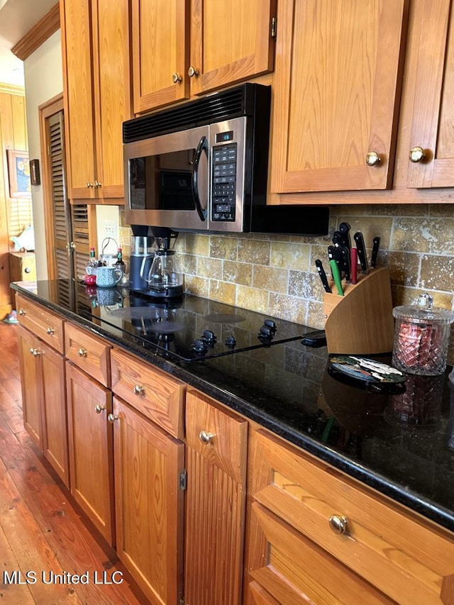 48 Fairway Dr, Natchez, MS 39120 - kitchen featuring dark stone countertops, backsplash, and wood-type flooring