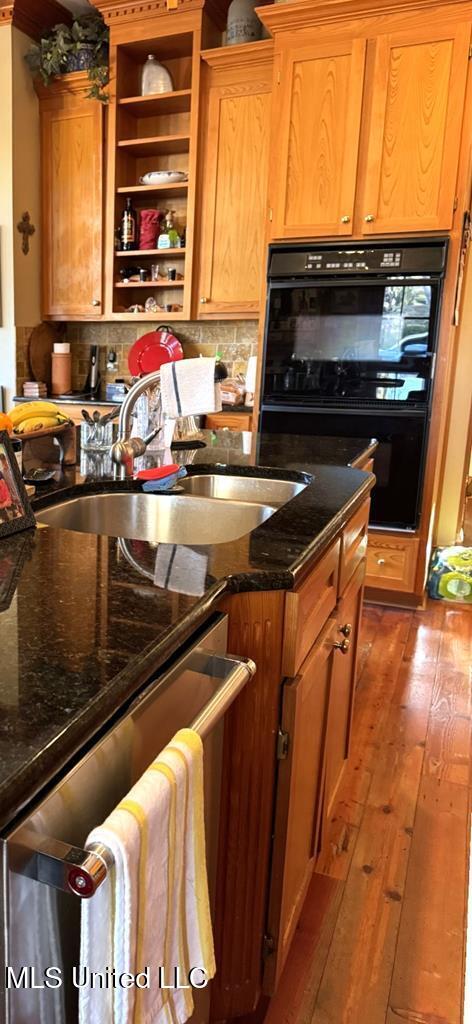 48 Fairway Dr, Natchez, MS 39120 - kitchen featuring hardwood / wood-style flooring, black double oven, dark stone counters, and tasteful backsplash