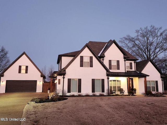 view of front of property with a standing seam roof, a front lawn, metal roof, and covered porch